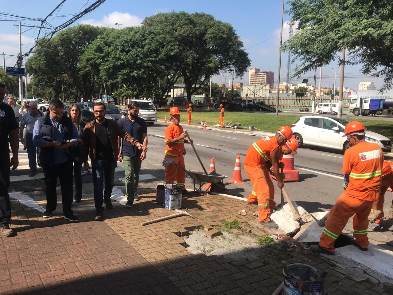 Homens em operação de zeladoria e vistoria na avenida 